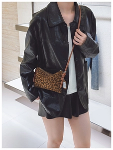 Classic leopard print crossbody bag with brown leather strap worn by a model in black leather jacket