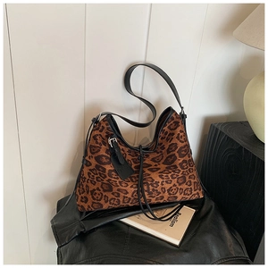 Detail of vintage leopard print hobo bag with adjustable leather strap and fashion tag