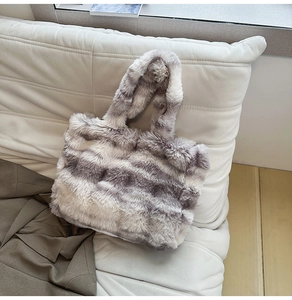 Gros plan d'un sac cabas en fausse fourrure douce avec texture rayée grise et blanche