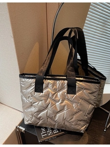 Silver quilted tote bag with large diamond stitching and black straps for women