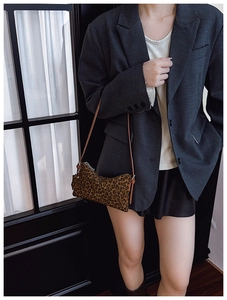 Detail of trendy leopard print shoulder bag with brown leather strap and zip closure
