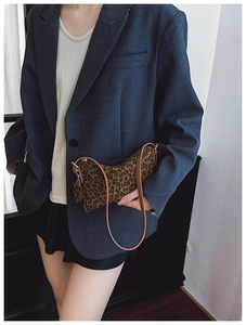Detail of vintage leopard print crossbody bag with sleek brown strap and zip closure