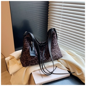 Detail of leopard print hobo bag featuring black leather straps and fashion hangtag