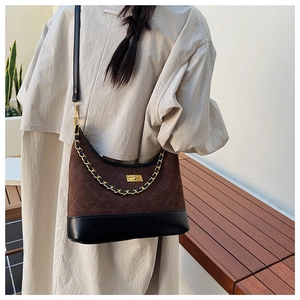 Detail of dark brown quilted suede hobo bag with gold twist lock and leather chain strap