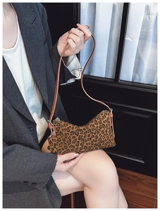 Detail of trendy leopard print underarm bag with slim brown leather shoulder strap