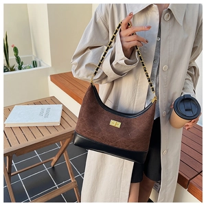 Chic quilted dumpling bag with chain strap shown on a model in a cozy urban setting