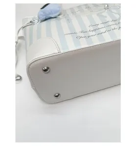 Détail du fond du sac cabas avec pieds en métal argenté et finition en cuir texturé