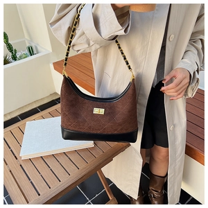 Detail of rhombic quilted suede bag with gold twist lock and metal chain strap