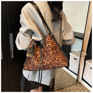Close-up of leopard print shoulder bag with black leather straps and fashion tag