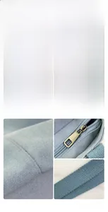 Detail view of blue canvas tote bag showing white pom-pom charm and durable metal zipper