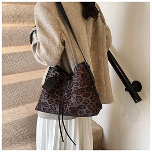 Detail of leopard print bucket bag featuring black leather strap and Fashion tag