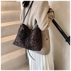 Close-up of leopard print shoulder bag featuring drawstring closure and fashion leather tag