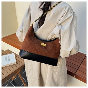 Detail of the diamond quilted texture and golden twist-lock closure on the hobo bag