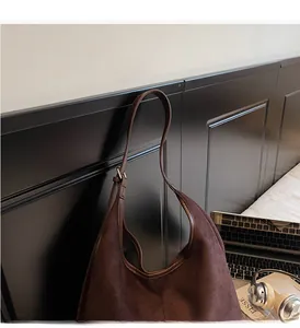 Vue détaillée du sac cabas en daim marron foncé avec bordures en cuir et texture douce