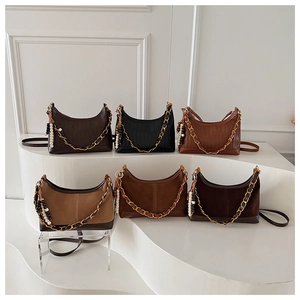 Detail view of multi-color suede crossbody hobo bags with gold chains and bead charms