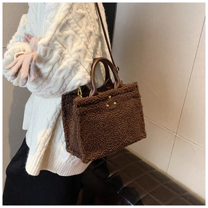 Detail view of brown plush teddy fabric shoulder bag with smooth leather handles