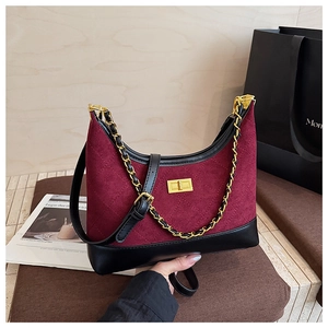 Detail of burgundy suede hobo bag featuring quilted stitching and gold chain leather strap