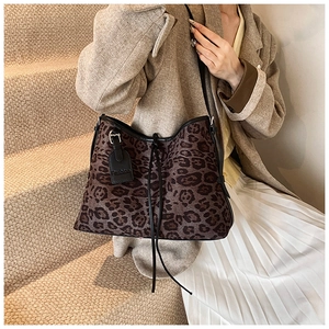 Detail of leopard print tote bag with black drawstring closure and fashion leather tag