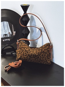 Detail of leopard print crossbody bag with dual straps and premium hardware