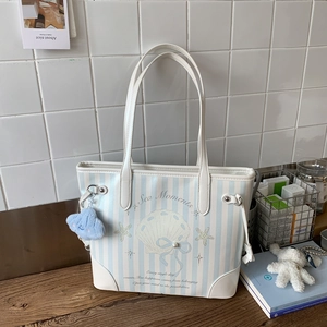 Détail du sac cabas à rayures bleues et blanches avec imprimé coquillage et charm nuage