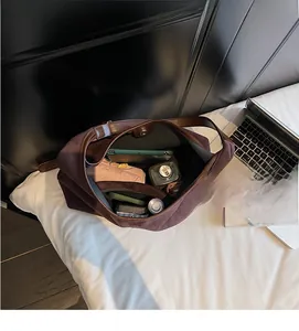 Vue détaillée de l'intérieur spacieux d'un grand sac cabas en daim marron avec accessoires
