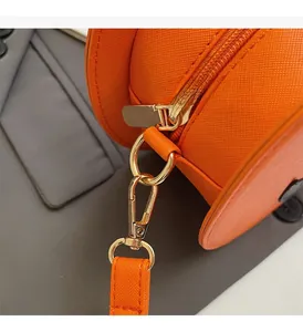 Detail of pumpkin orange Saffiano leather bag with premium light gold hardware and metal clasps