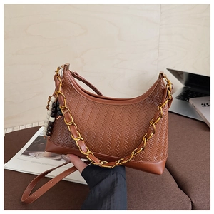 Detail of brown woven hobo bag with gold chain strap and stylish beaded charm accessory