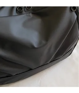 Macro shot of smooth black oxford cloth fabric and metal zipper detail on cross-body bag