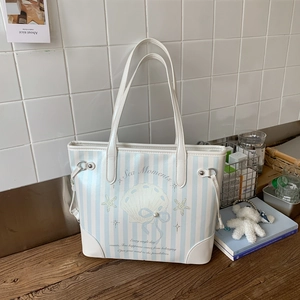 Détail du sac fourre-tout à rayures bleues avec imprimé coquillage et nœud perlé