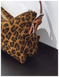 Detail shot of leopard print handbag featuring high-quality suede texture and silver hardware