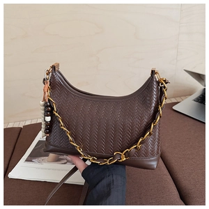 Detail of dark brown hobo bag with woven texture, chunky gold chain and wooden bead charm
