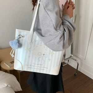 Détail du sac cabas à rayures bleues avec broderie coquillage, perles et peluche