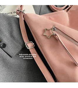Close-up of pink shoulder bag featuring star zipper pull and adjustable metal buckle