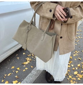 Detail of grey-blue matte leather tote bag with fine shoulder straps in autumn setting