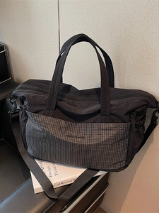 Large black travel tote bag with grey plaid pocket and adjustable shoulder strap for women