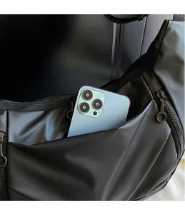 Close-up of spacious front zip pocket on black nylon crossbody bag with phone holder