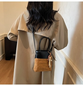 Detail of contrast stitch bucket bag with quilted suede and decorative wood beads