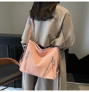 Pink tote bag detail with star-shaped metal zippers and smooth matte leather texture