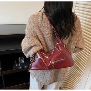 Vue portée d'un grand sac bandoulière bordeaux avec fermeture éclair et pendentif