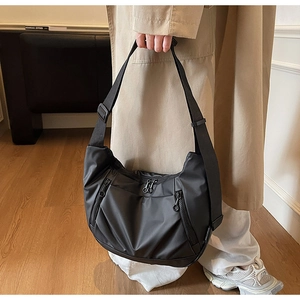 Detail of black nylon crescent bag with double zipper and adjustable strap