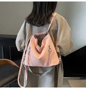 Close-up of pink leather tote bag with vertical zippers and star pendant details