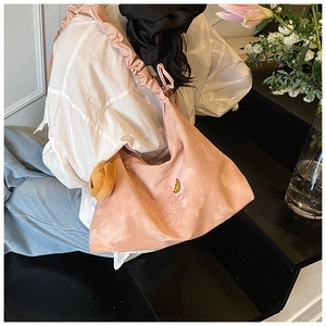 Pink shoulder bag detail with ruffled strap and merci cerre embroidery on soft nylon