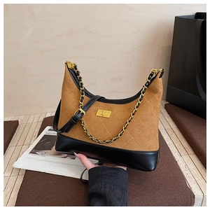 Detail of vintage quilted hobo bag featuring matte brown suede and gold buckle
