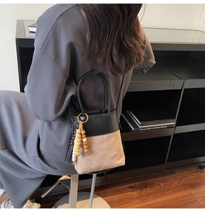 Detail of crossbody bucket bag with suede patchwork and diamond quilted pattern