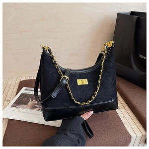 Detailed view of quilted black suede hobo bag with gold chain and metal lock closure