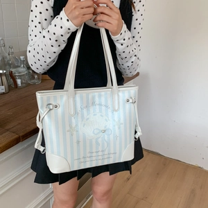 Gros plan du sac cabas à rayures bleues avec texte Sea Moments et détail de perle marine