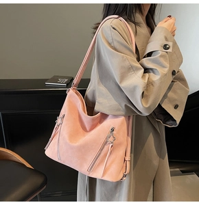Pink suede tote bag detail featuring vertical zippers with star pullers and long tassels