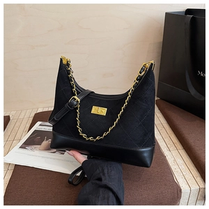 Detailed view of quilted suede texture and gold chain strap on the black crossbody bag