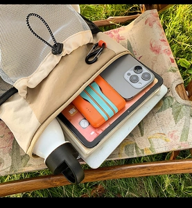 Détail du sac de randonnée en nylon kaki montrant sa grande capacité avec téléphone et gourde