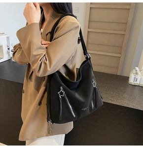 Detail of black large capacity hobo tote bag featuring star-shaped silver metal zippers